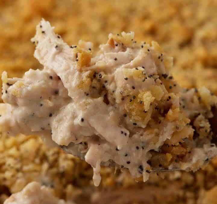 A serving spoon scooping out chicken casserole.