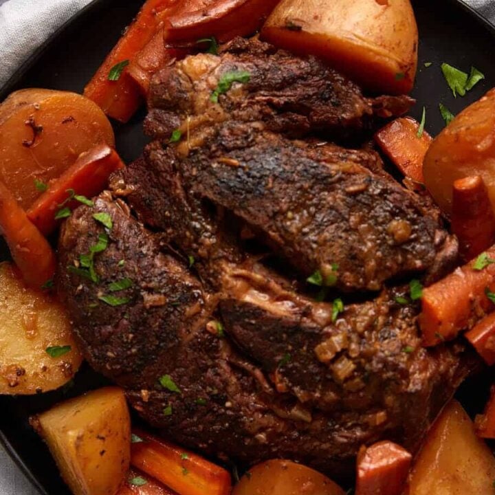 A platter of roast beef with carrots and potatoes.