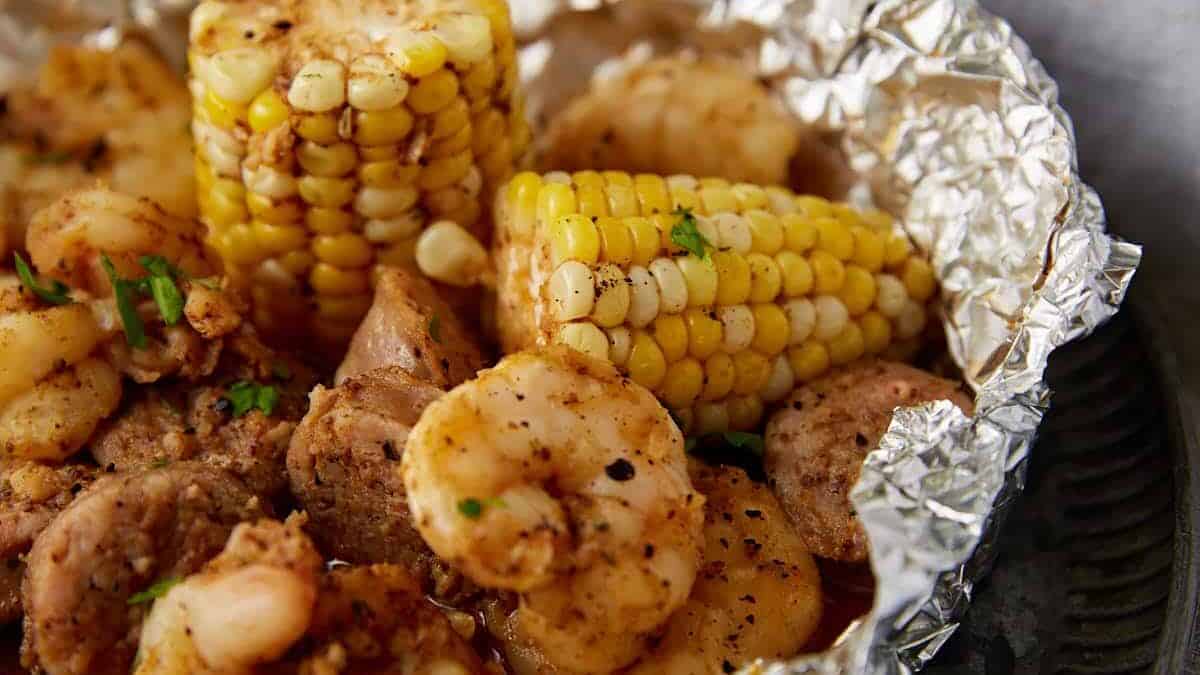 A single serving of a shrimp boil in aluminum foil.