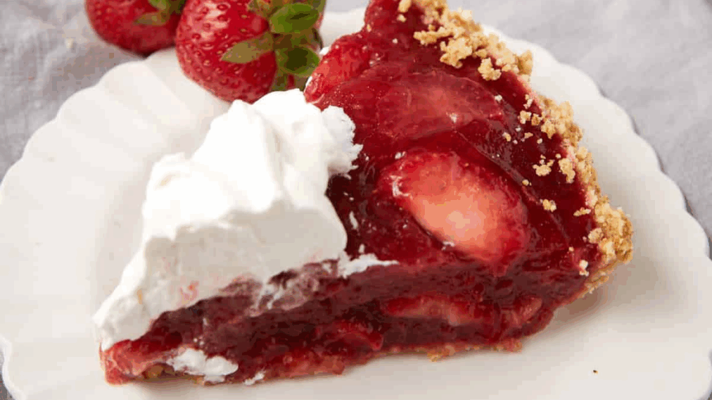 A slice of strawberry pie with whipped cream on top.