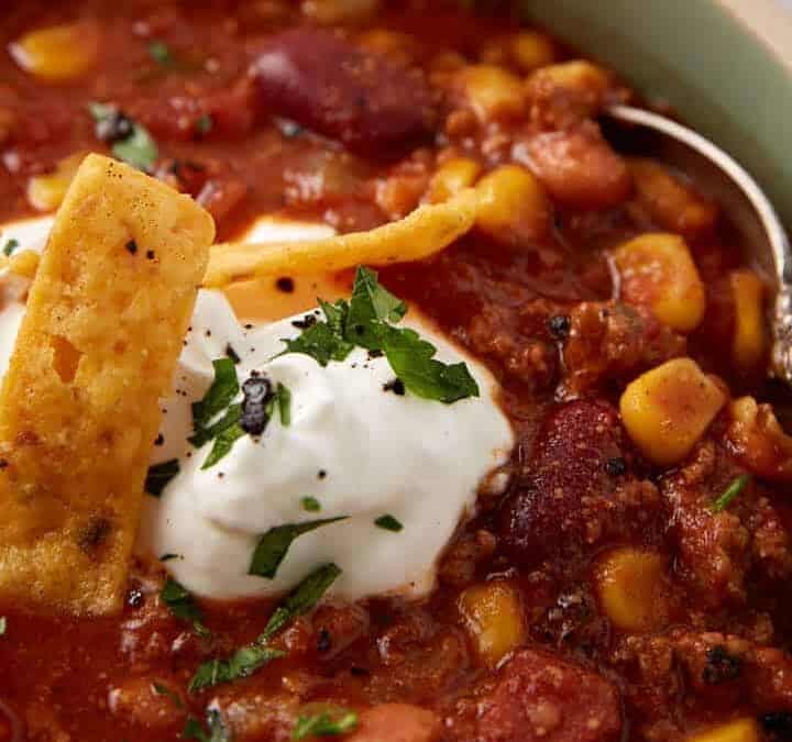 Taco soup topped with sour cream and corn chips.