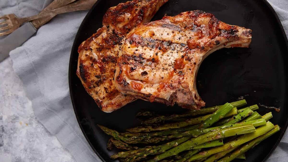 Grilled pork chops with peach bbq sauce on a plate.