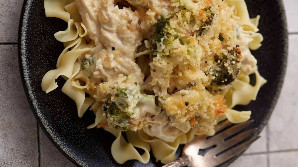 Broccoli chicken divan on a plate over noodles.