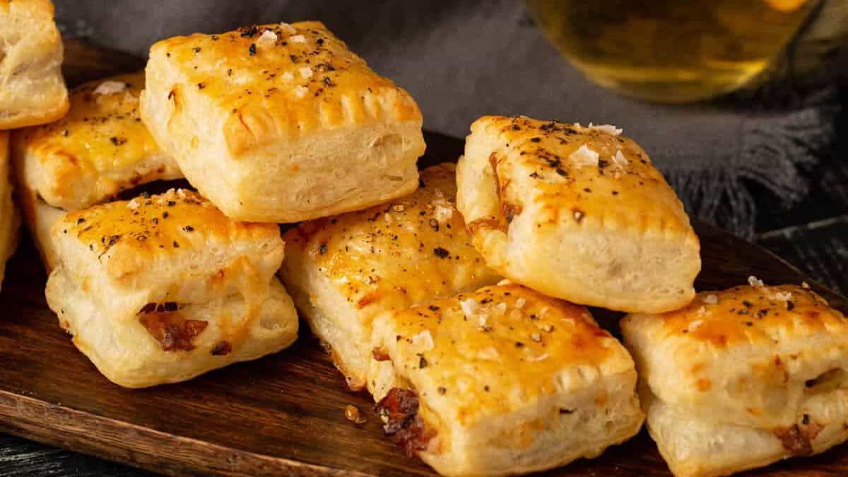French onion pastry bites on a platter with a glass of wine.