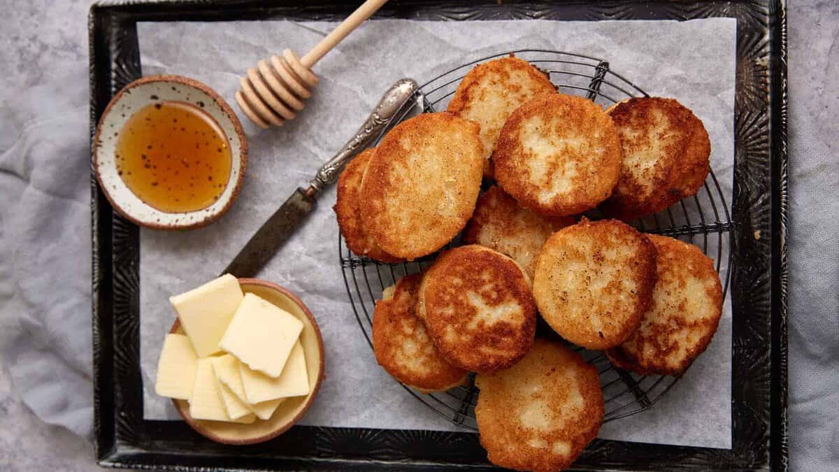 A tray with hot water cornbread, butter and honey.