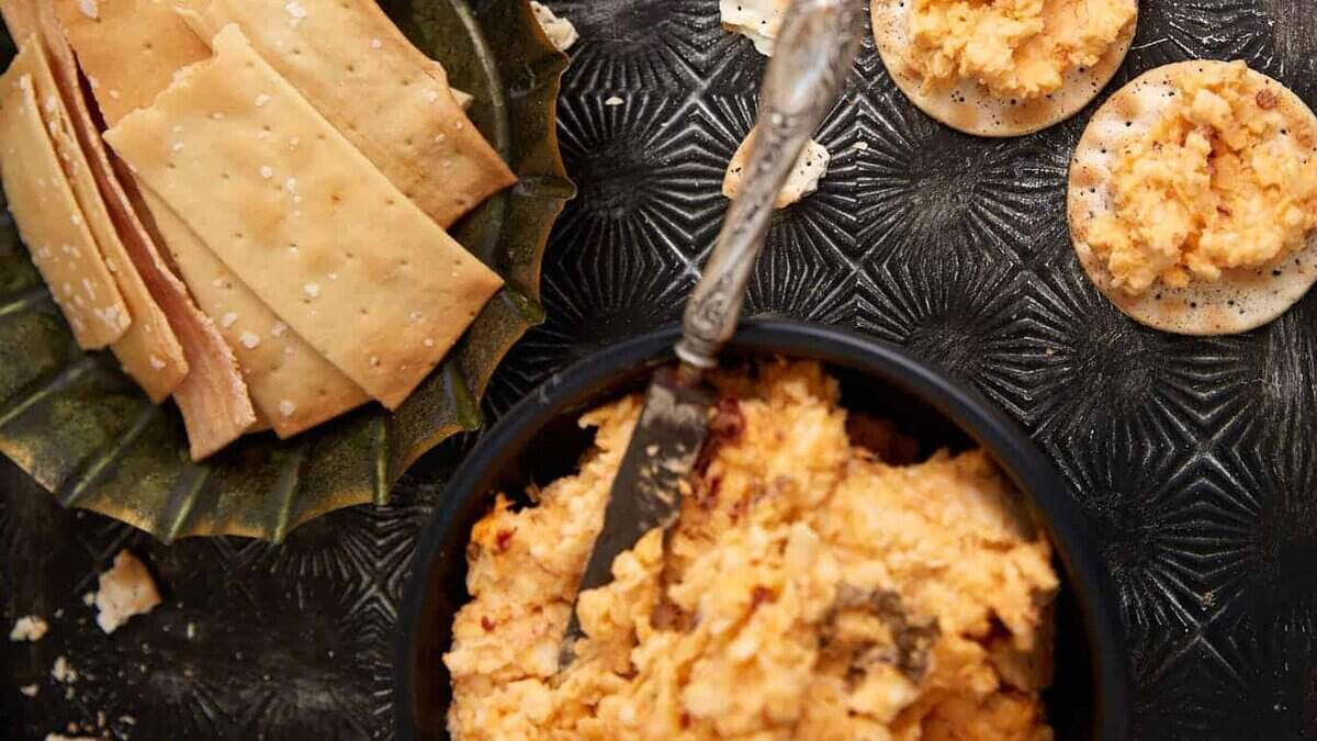 A tray of pimento cheese dip on crackes.