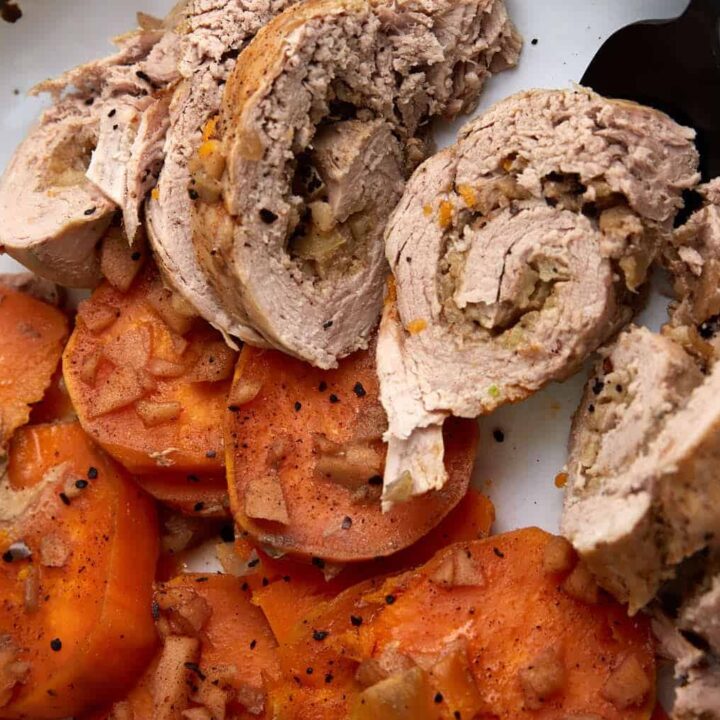 A serving fork removing slices of slow cooked pork tenderloin.