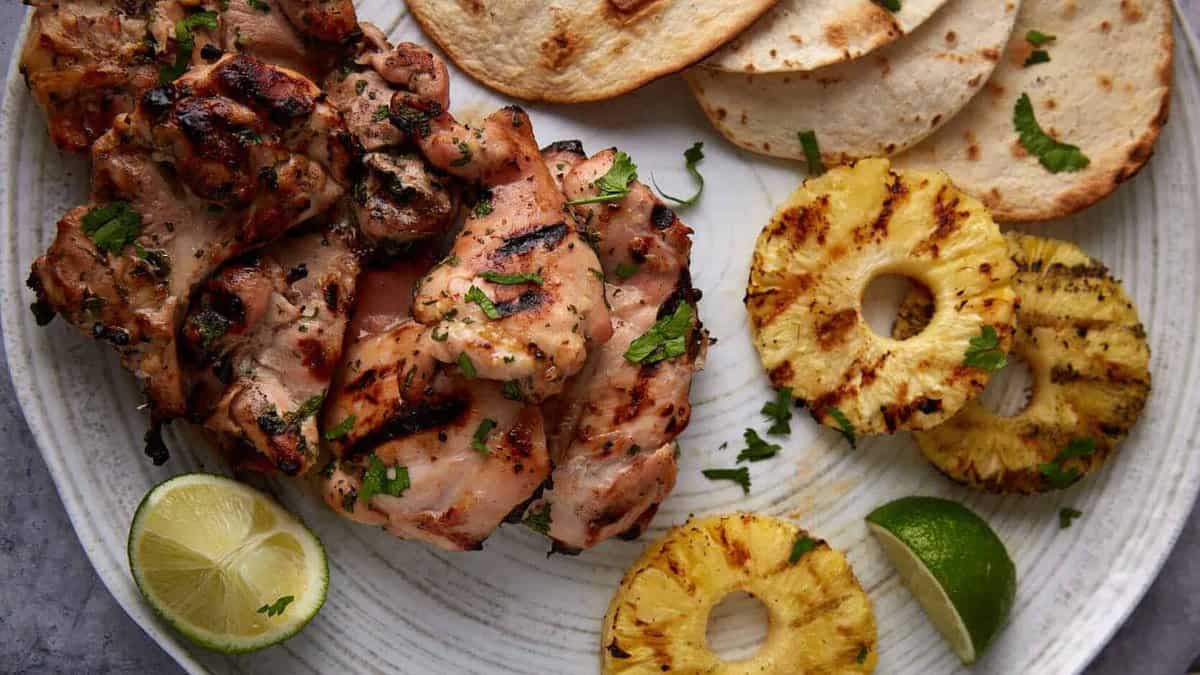 A platter of grilled chicken with grilled pineapple.
