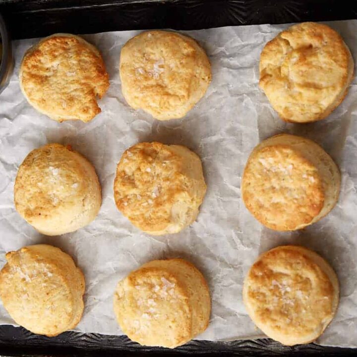 Air fryer biscuits next to a bowl of butter slices.