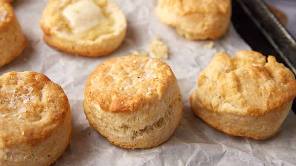 A baking tray with air fryer biscuits on parchment paper.