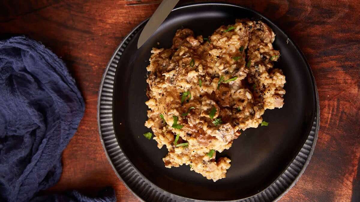 Mushroom soup and rice with a slow cooker pork chop on a plate.