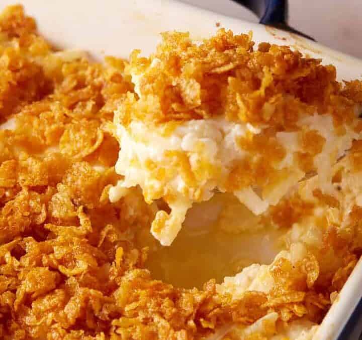 A spoon full of hashbrown casserole.