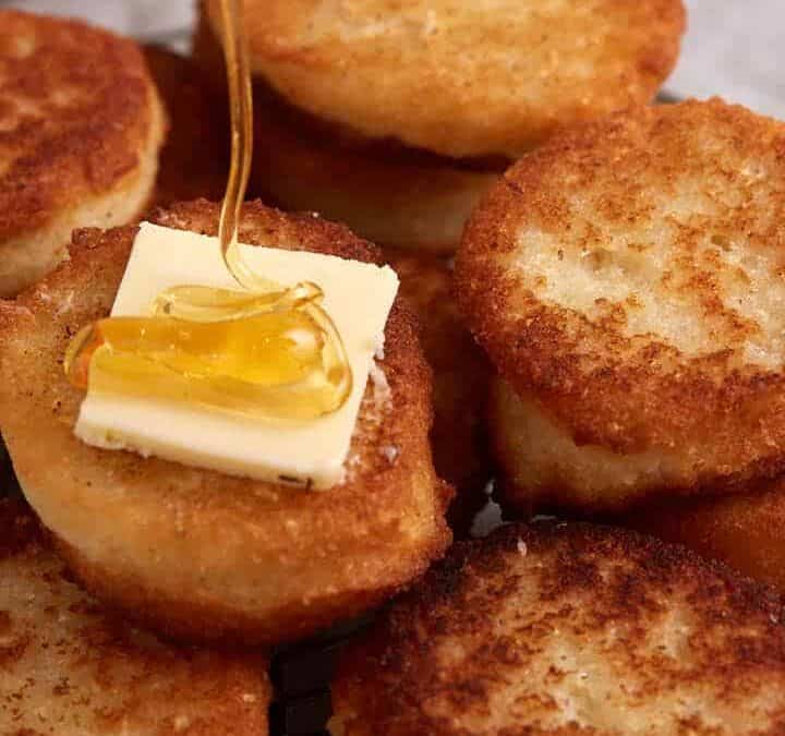 A rack of hot water cornbread with butter and honey.