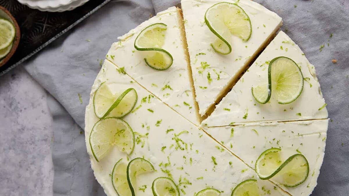 A sliced key lime pie next to a pie server.