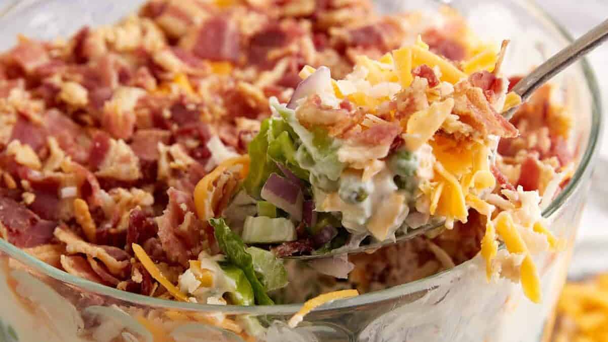 A spoon full of seven layer salad.