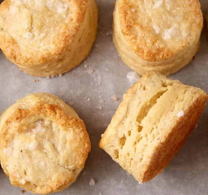 A batch of buttermilk biscuits on parchment paper.