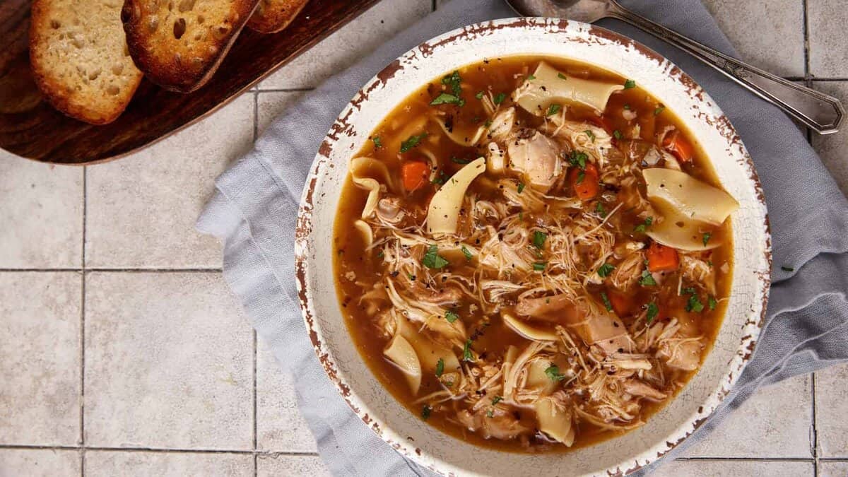 A bowl of crock pot chicken noodle soup.