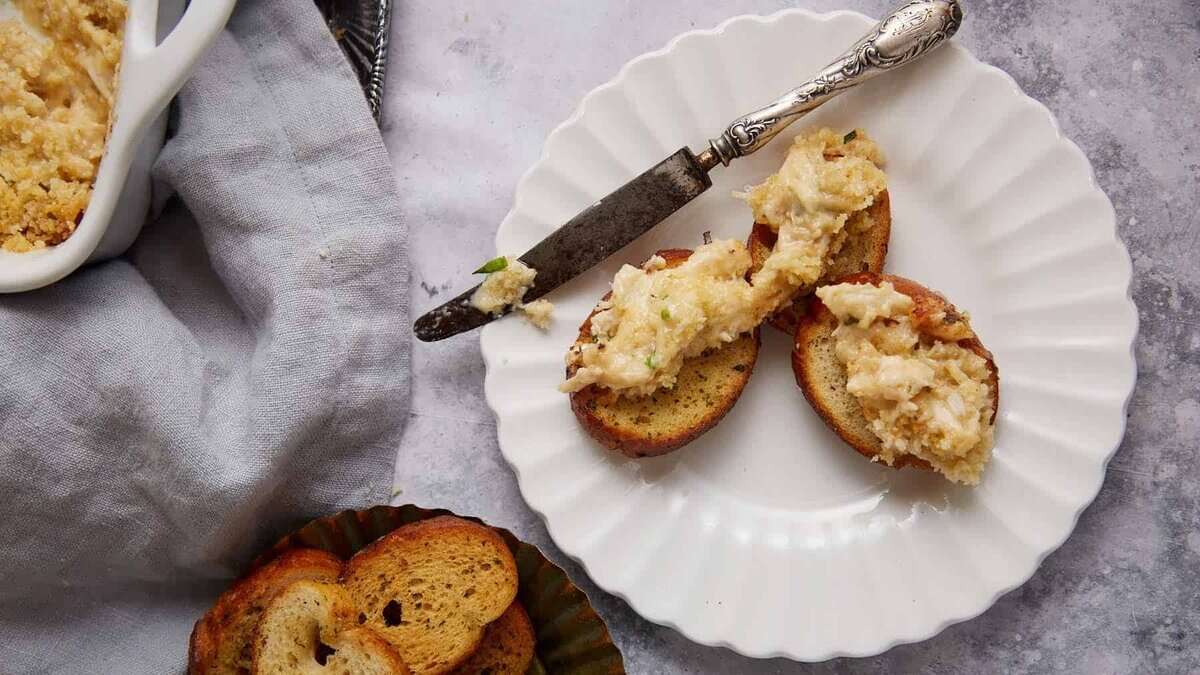 A small plate with crostini and crab dip.