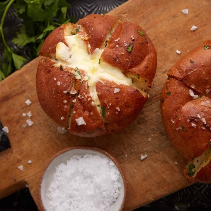 Two stuffed garlic rolls on a wooden board.