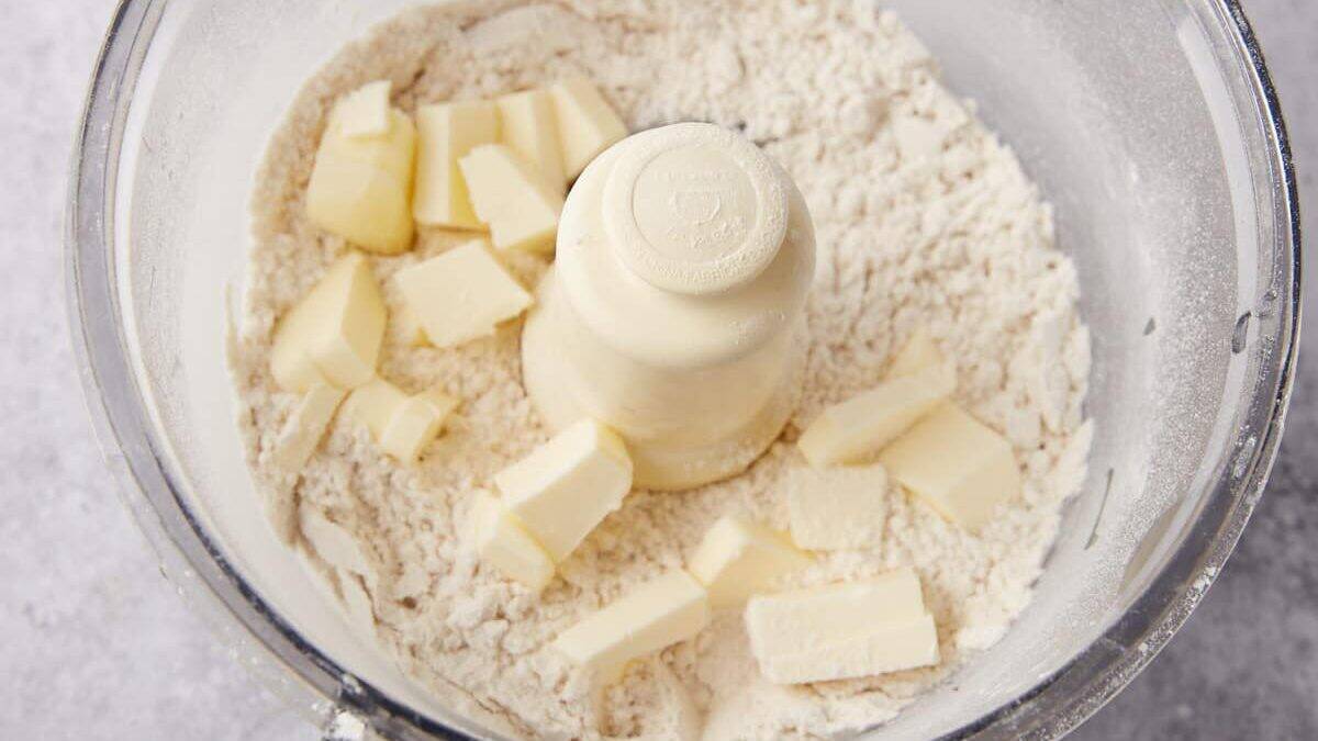 A food processor with chunks of butter in the flour mixture.