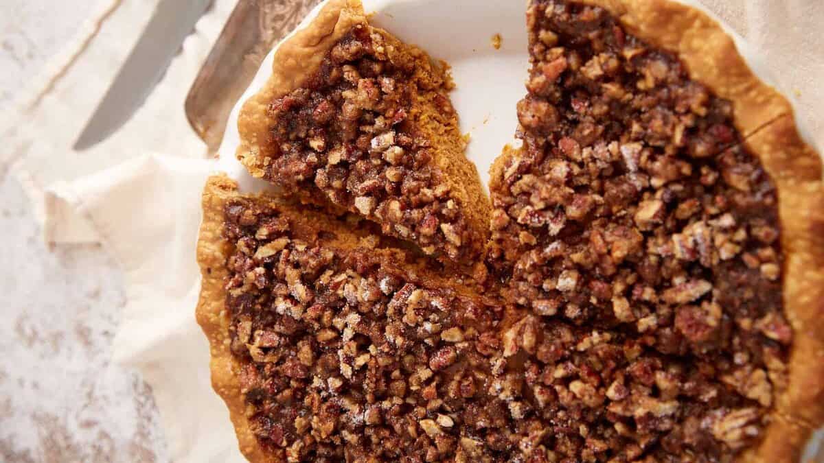 A pumpkin pie with a slice removed.