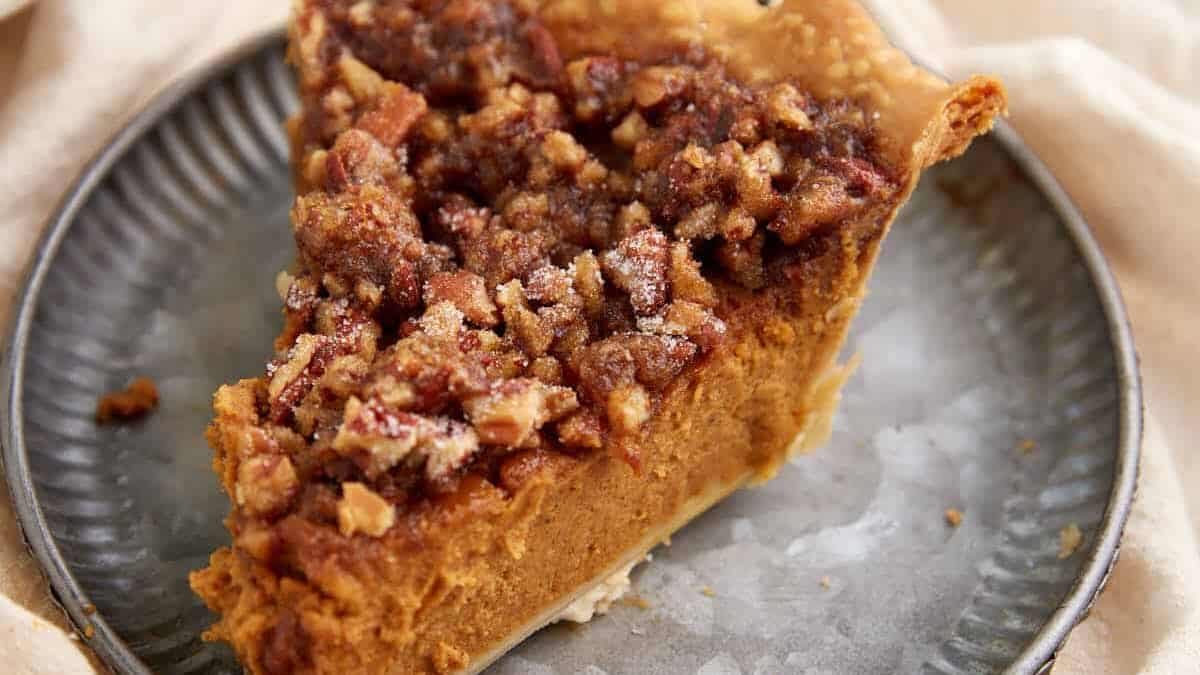 A slice of pumpkin pie topped with pralines.