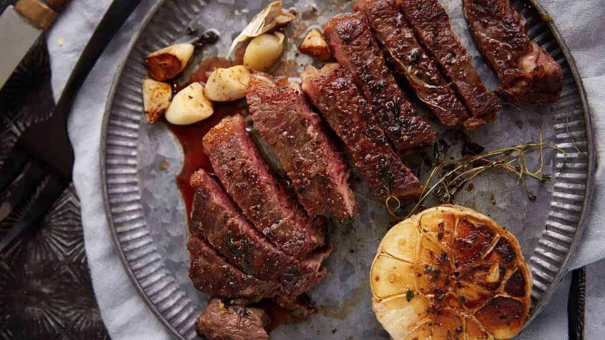 A platter with sliced ribeye steak.