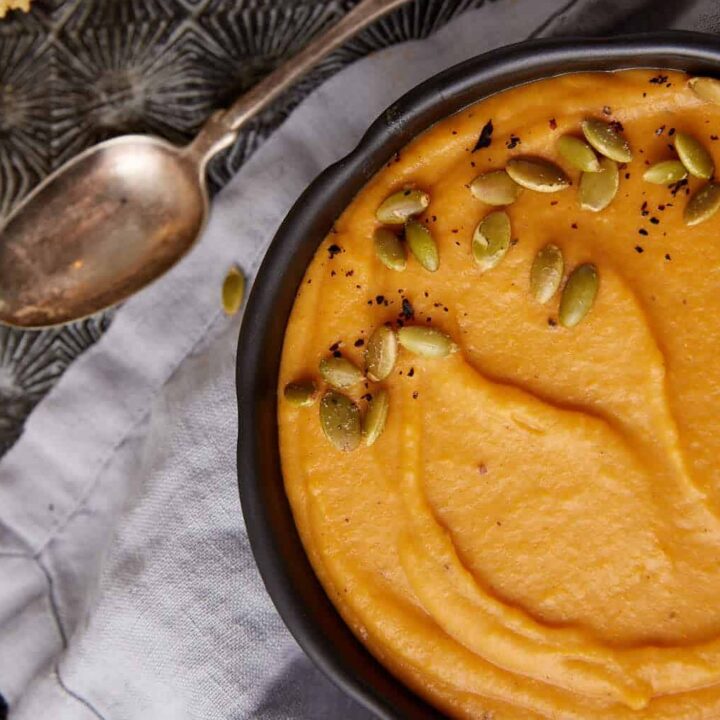 Sweet potato soup in a bowl with pumpkin seeds.