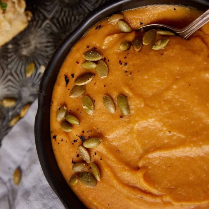 A bowl of sweet potato soup with a spoon in it.