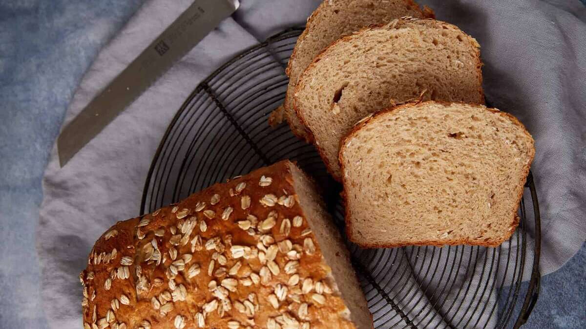 Honey oat bread sliced on a wire rack.