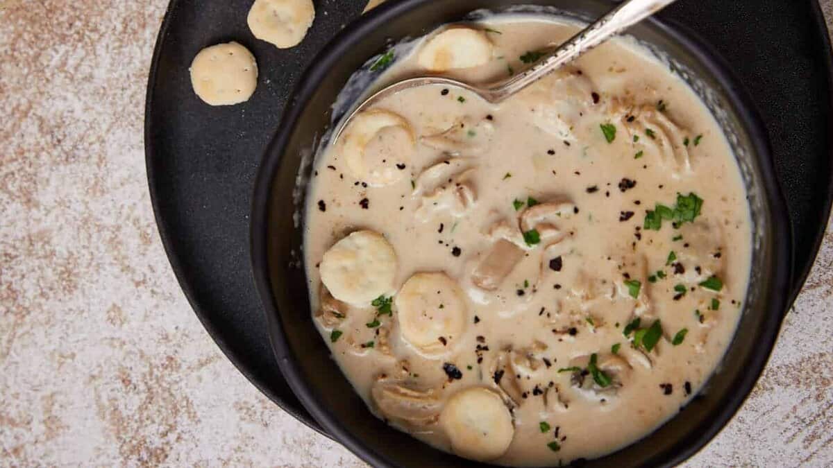 A bowl of oyster soup with oyster crackers.
