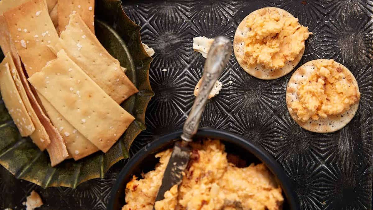 A tray of pimento cheese dip on crackes.