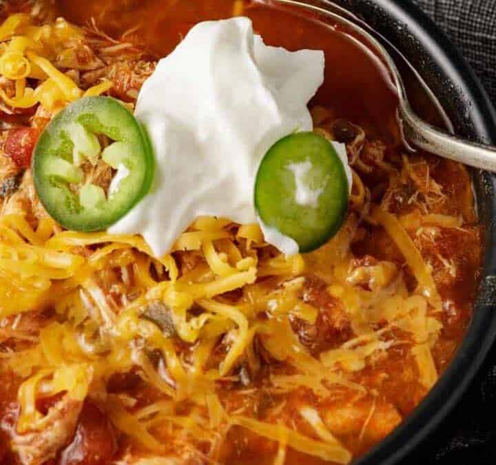 A bowl of chicken chili with sour cream