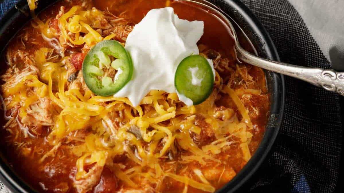 A bowl of chicken chili with sour cream