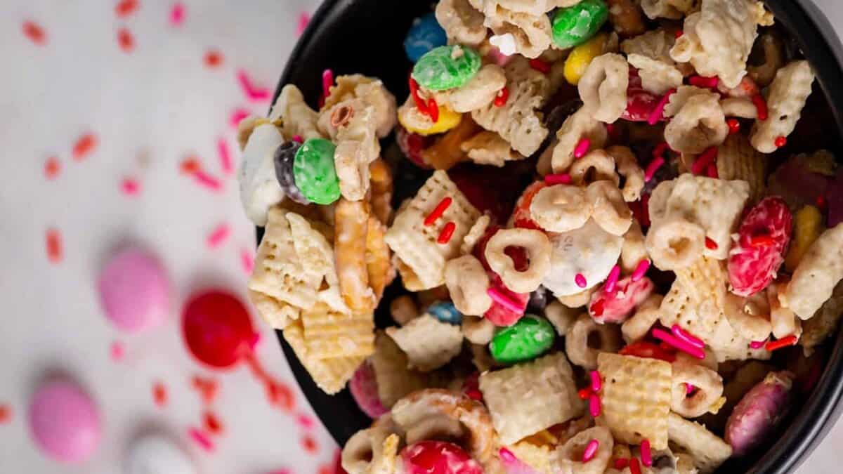 Chex mix with white chocolate decorated with Valentines day sprinkles.