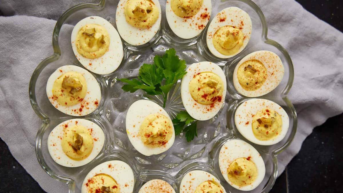 a platter of deviled eggs with parsley on the platter.