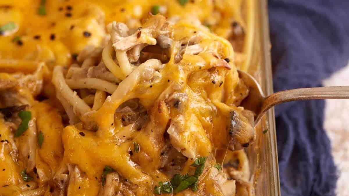 A casserole dish of chicken tetrazzini with a serving spoon.