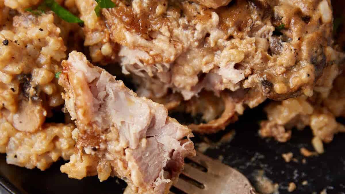 Mushroom soup and rice with a slow cooker pork chop on a plate.