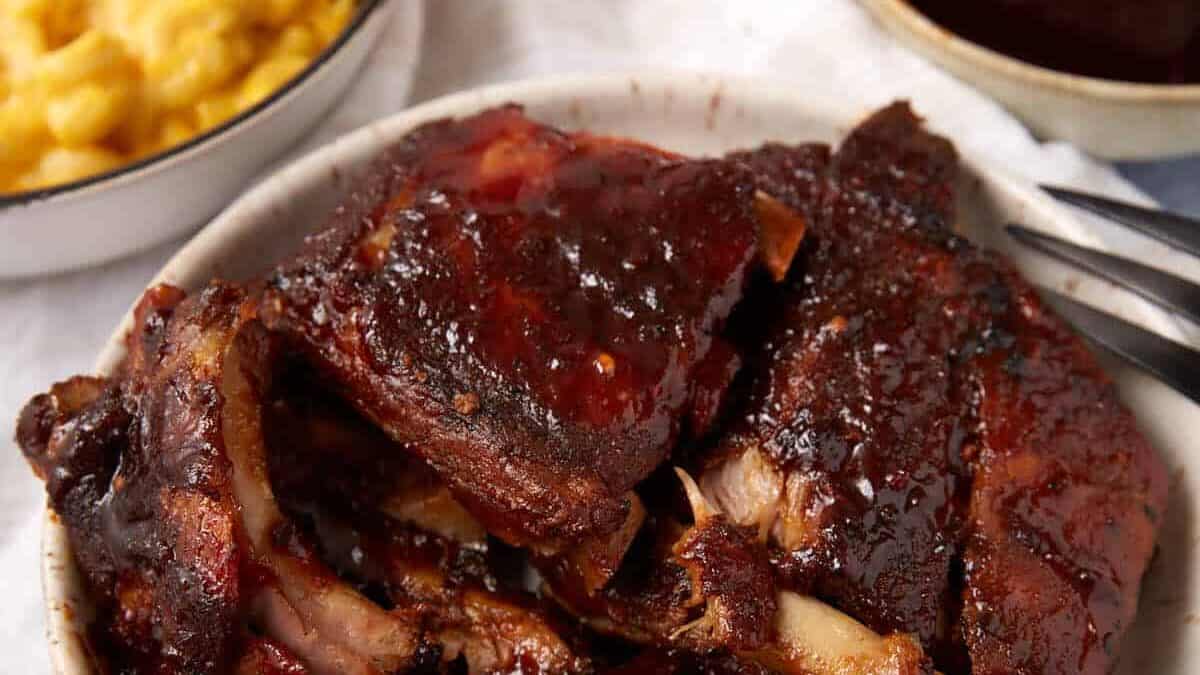 Barbecue ribs with a bowl of sacue.